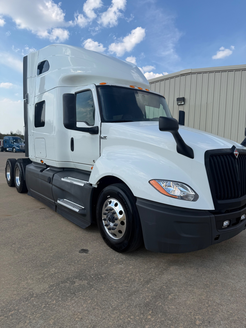 Truck cab of a 2021 International LT625 tractor in white, front-right view with sleeper cab and black bumper.