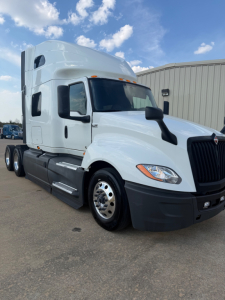 Truck cab of a 2021 International LT625 tractor in white, front-right view with sleeper cab and black bumper.