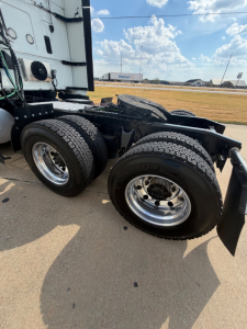 Truck rear dual tires and fifth wheel on a 2021 International LT625 tractor chassis showing dual rear axles and chrome wheels.