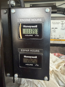 Truck cab interior gauge panel showing Engine Hours and ESPAR Hours with Honeywell meters.