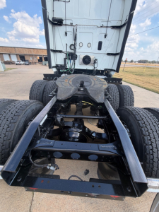 Truck chassis and rear cab view showing fifth wheel, dual rear axles, and frame rails for a 2021 International LT625 with visible components and drivetrain.
