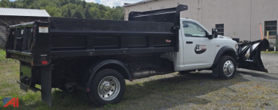 Ram 5500 dump truck with plow attachment and black dump bed, side view in a lot