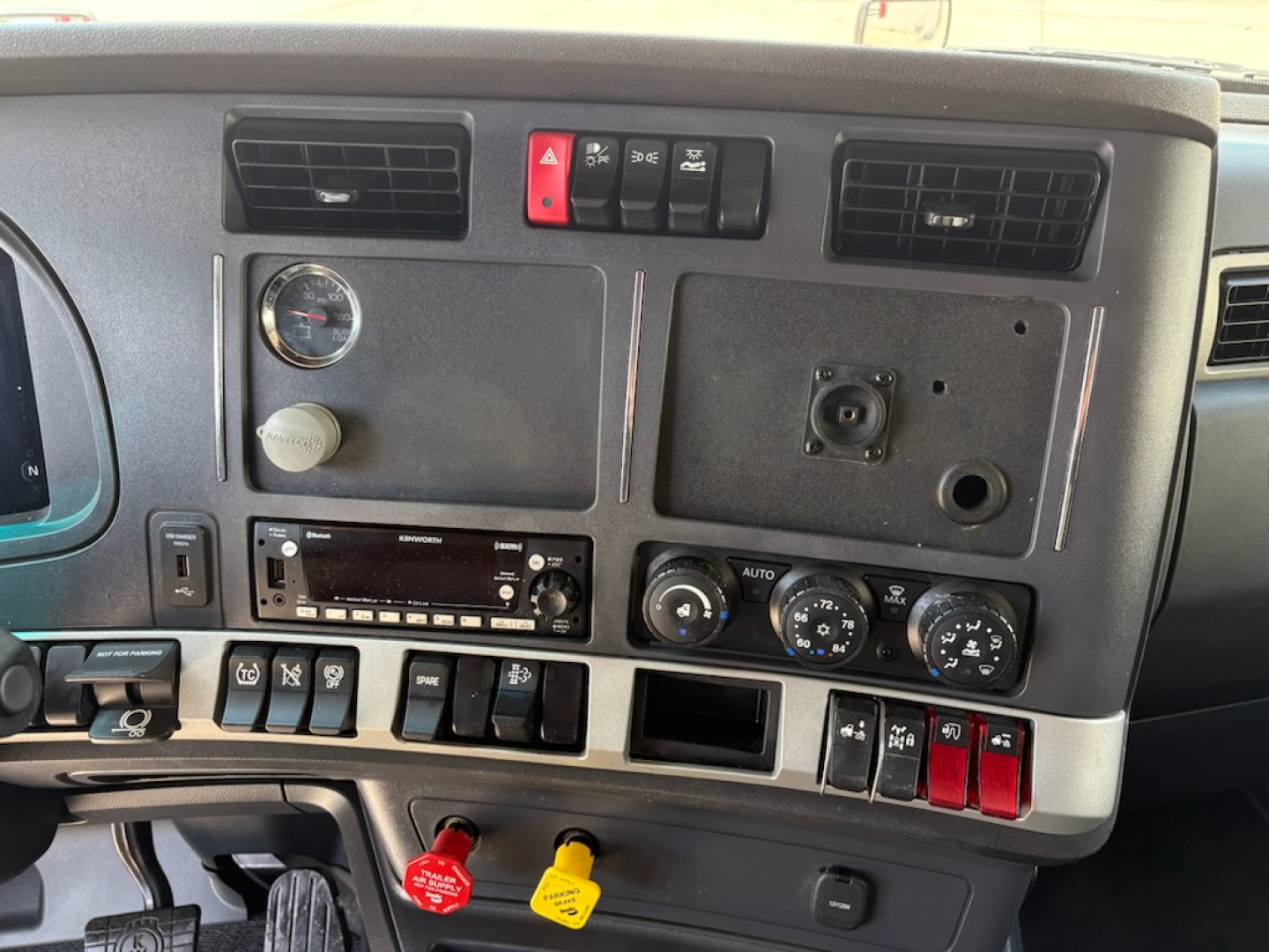 Kenworth T680 dashboard showing various switches, gauges, and control panels visible.
