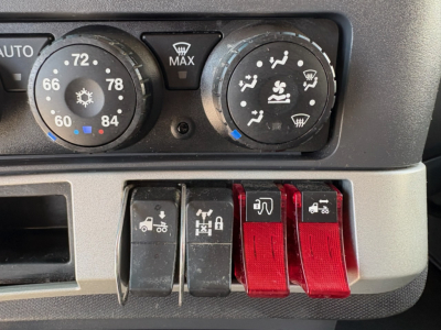 Kenworth T680 dash showing climate controls and rocker switches. Visible text includes AUTO, 72, 60, 84, MAX, DEF heater icons, and four red/black toggle switches.