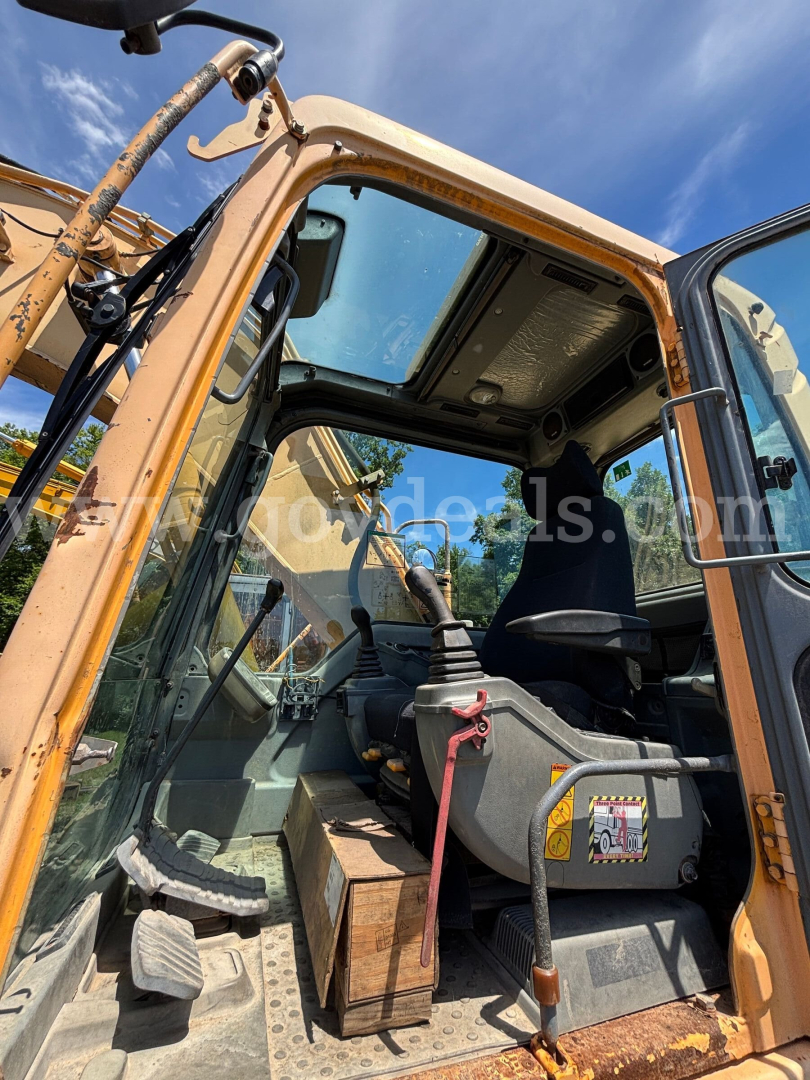 Excavator cab interior of a 2005 Volvo EC160B showing operator seat, controls, and entry steps from an open door.