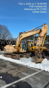 Excavator EC160B with VOLVO branding; side text on boom and body; snow on ground; date/time overlay top left; stock yard setting.