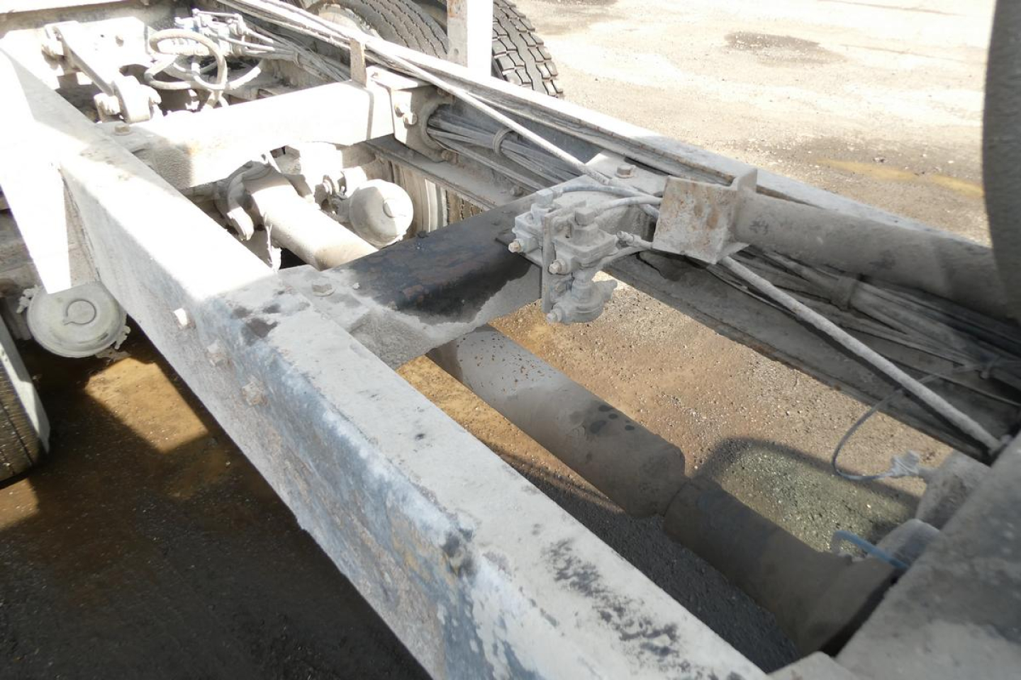 Peterbilt truck frame and engine bay area showing chassis, hydraulic lines, and components of a dump truck chassis.