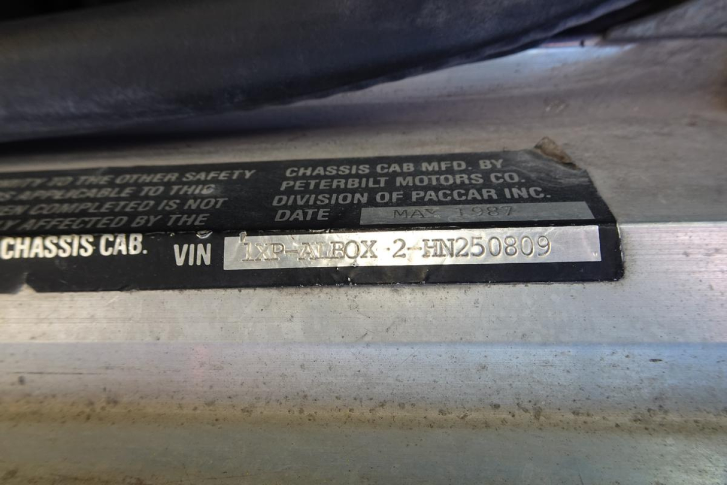 Chassis cab VIN plate showing VIN 1XPALB0X2HN250809 with surrounding text about Peterbilt Motors Co and division of PACCAR Inc.