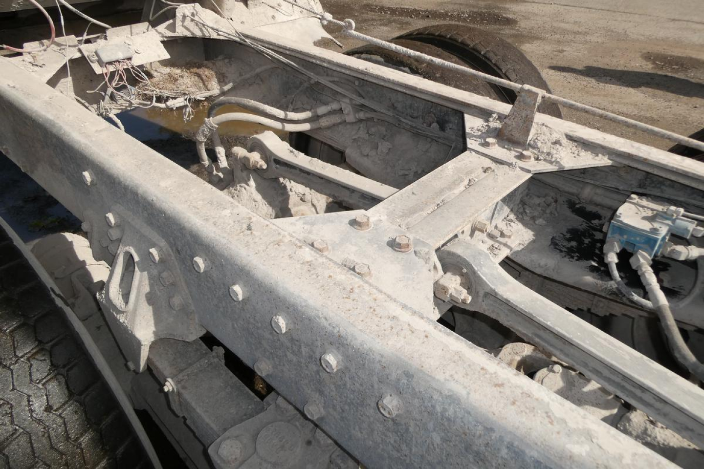 Chassis frame and hydraulic lines of a 1987 Peterbilt 357 dump truck showing metal framework and mounting points.