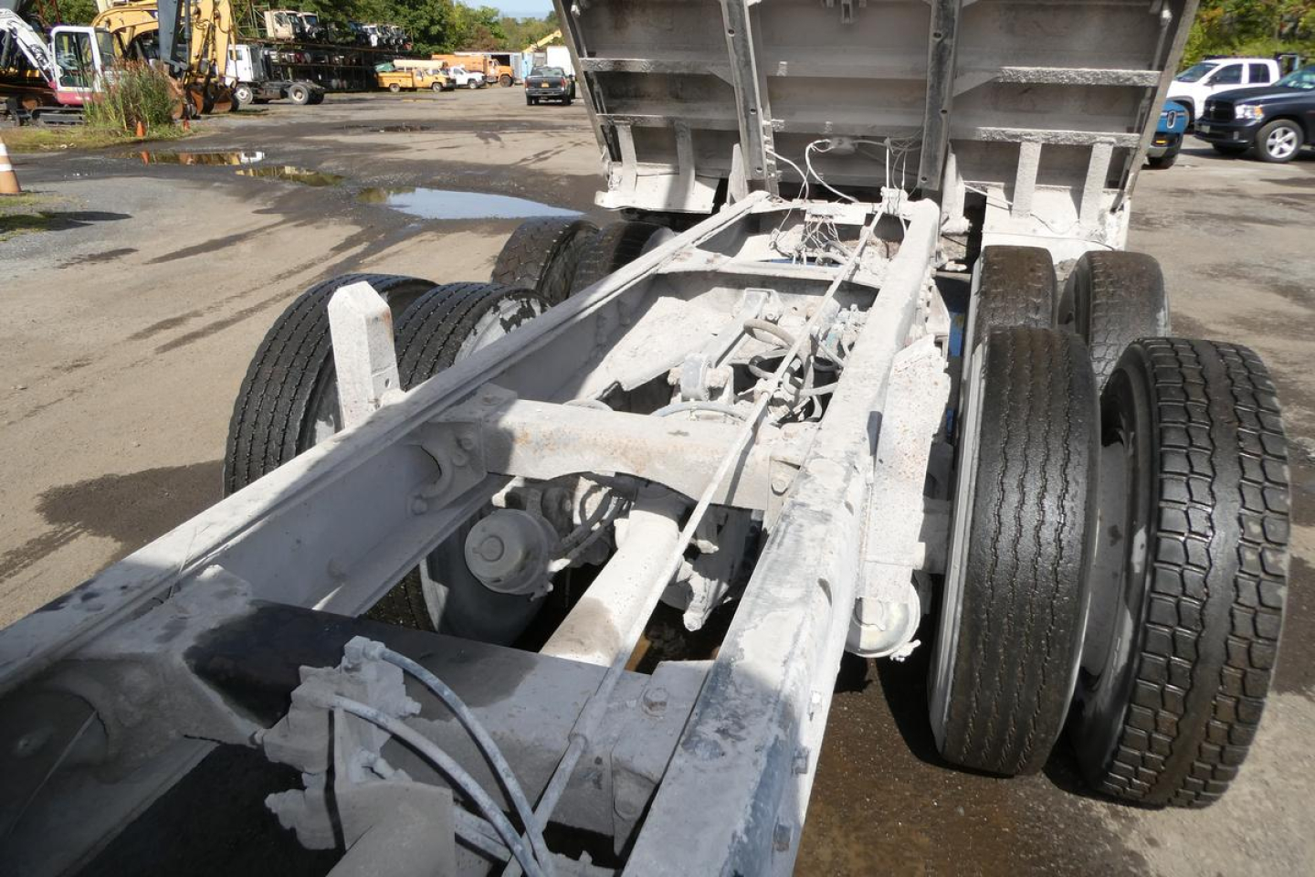 Peterbilt 357 dump truck chassis and rear axle seen from bed area, with dual rear wheels and raised bed. White/gray primer visible.