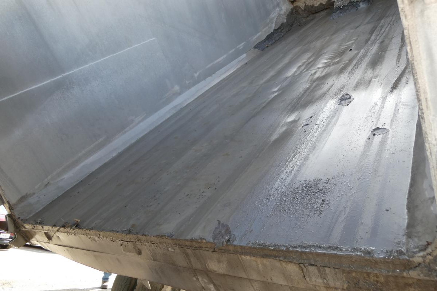 Dump bed of a Peterbilt truck showing metal bed with welds and edge. No legible model numbers visible.