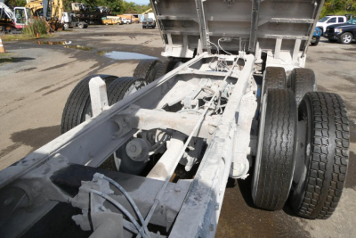 Peterbilt 357 dump truck chassis and rear axle seen from bed area, with dual rear wheels and raised bed. White/gray primer visible.