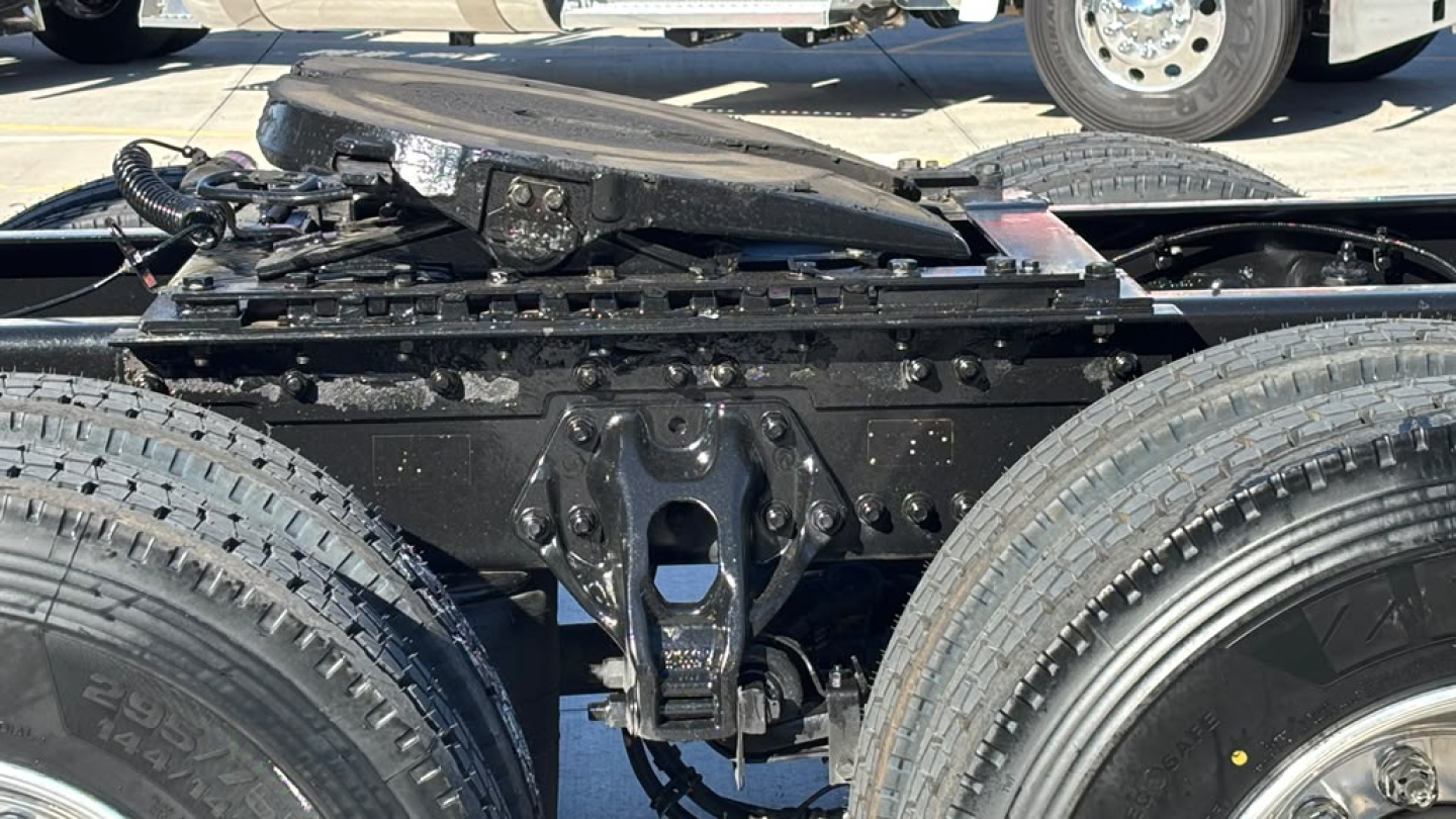 Kenworth T680 chassis view showing rear frame, suspension hangers, and dual rear tires with drivetrain shelter.