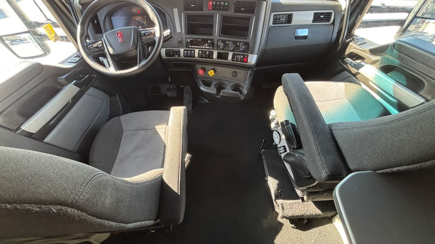 Kenworth T680 truck interior showing steering wheel, dashboard, and seats.