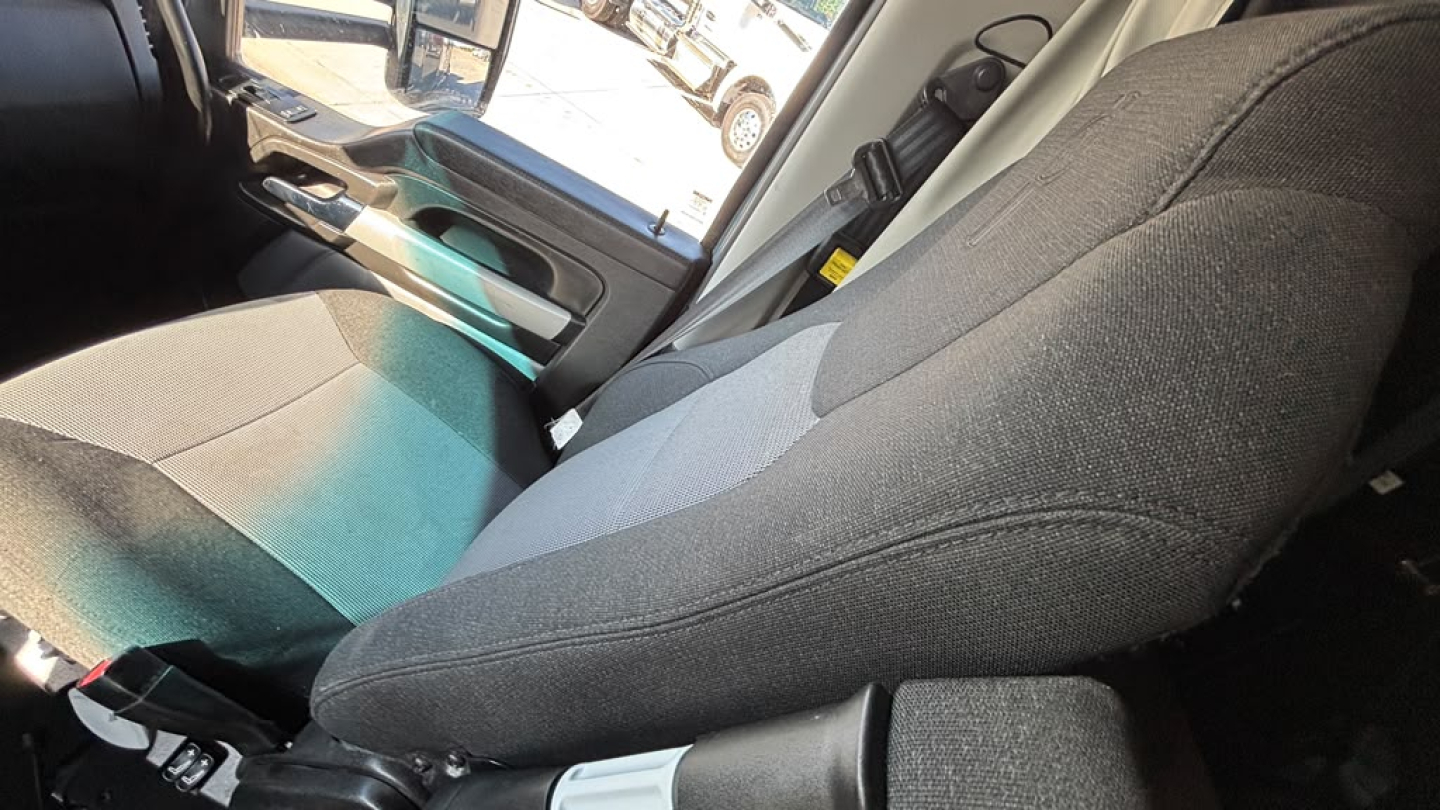 Kenworth T680 interior seat view with fabric seat and door panel.