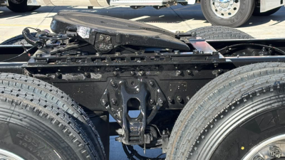 Kenworth T680 chassis view showing rear frame, suspension hangers, and dual rear tires with drivetrain shelter.