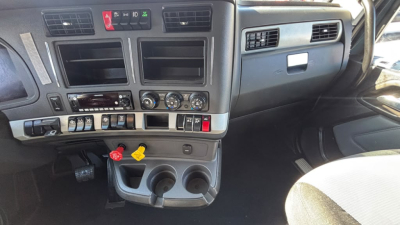 Kenworth truck dashboard showing center console with air vents, ignition area, and cup holders as seen in a truck cab interior.