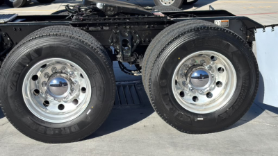 Kenworth T680 truck rear dual tires and suspension showing chrome wheel hubs and tire treads.