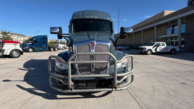 Kenworth T680 front view showing heavy-duty grille guard and bumper, chrome grille, large hood, front cameras, and bold Kenworth emblem.