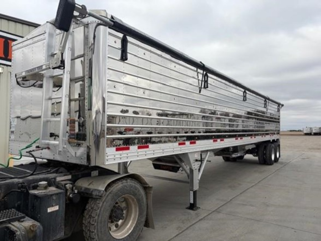 Timpte Super Hopper trailer in side view showing aluminum side panels and dual rear axles with landing gear.