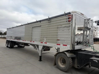 Timpte Super Hopper trailer side view showing aluminum paneled hopper with dual rear doors and landing gear. VIN 150118969139, stock 205428, new trailer.