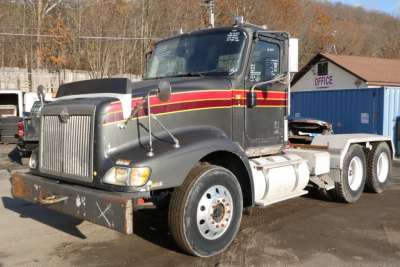 Truck cab and chassis of a 2005 International 9400 conventional daycab showing dual rear axles and front grille.