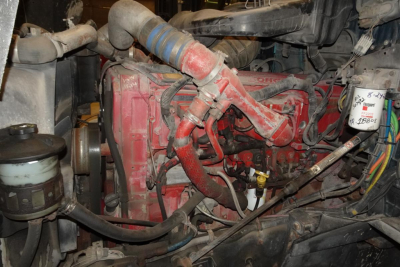 Engine bay of a 2005 International 9400 showing red engine components and hoses.