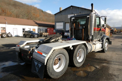 Truck chassis of a 2005 International 9400 conventional daycab showing rear view with dual rear axles and exhaust stack.