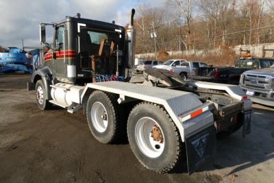 Truck chassis showing International 9400 daycab with 6x4 wheel configuration and hydraulic hook lift at rear