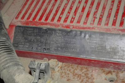 Vehicle identification plate on engine bay showing model and serial details with faded text.