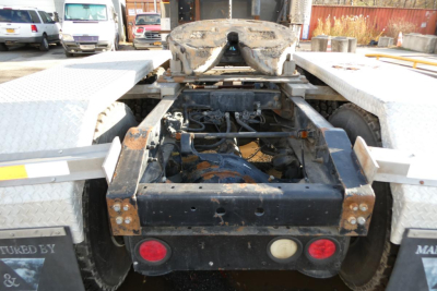 [Component] Rear view showing fifth wheel and drivetrain on a conventional daycab tractor.