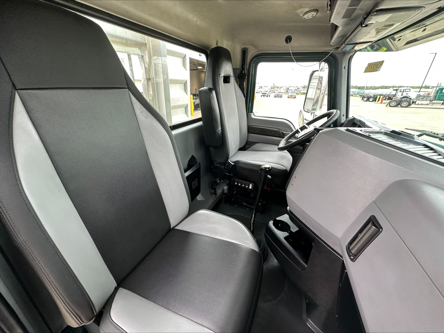 Interior cab seating of 2020 Mack PI64T truck showing driver and passenger seats and dashboard.