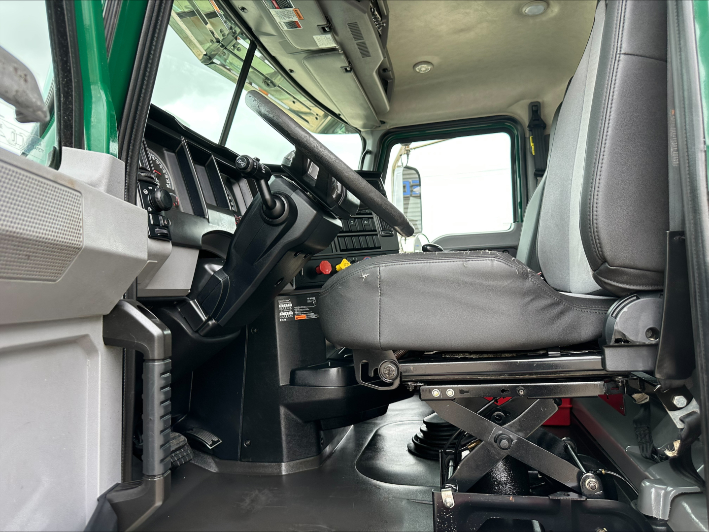Cab interior of a 2020 Mack PI64T daycab showing driver seat and dashboard with steering wheel and control stalks.