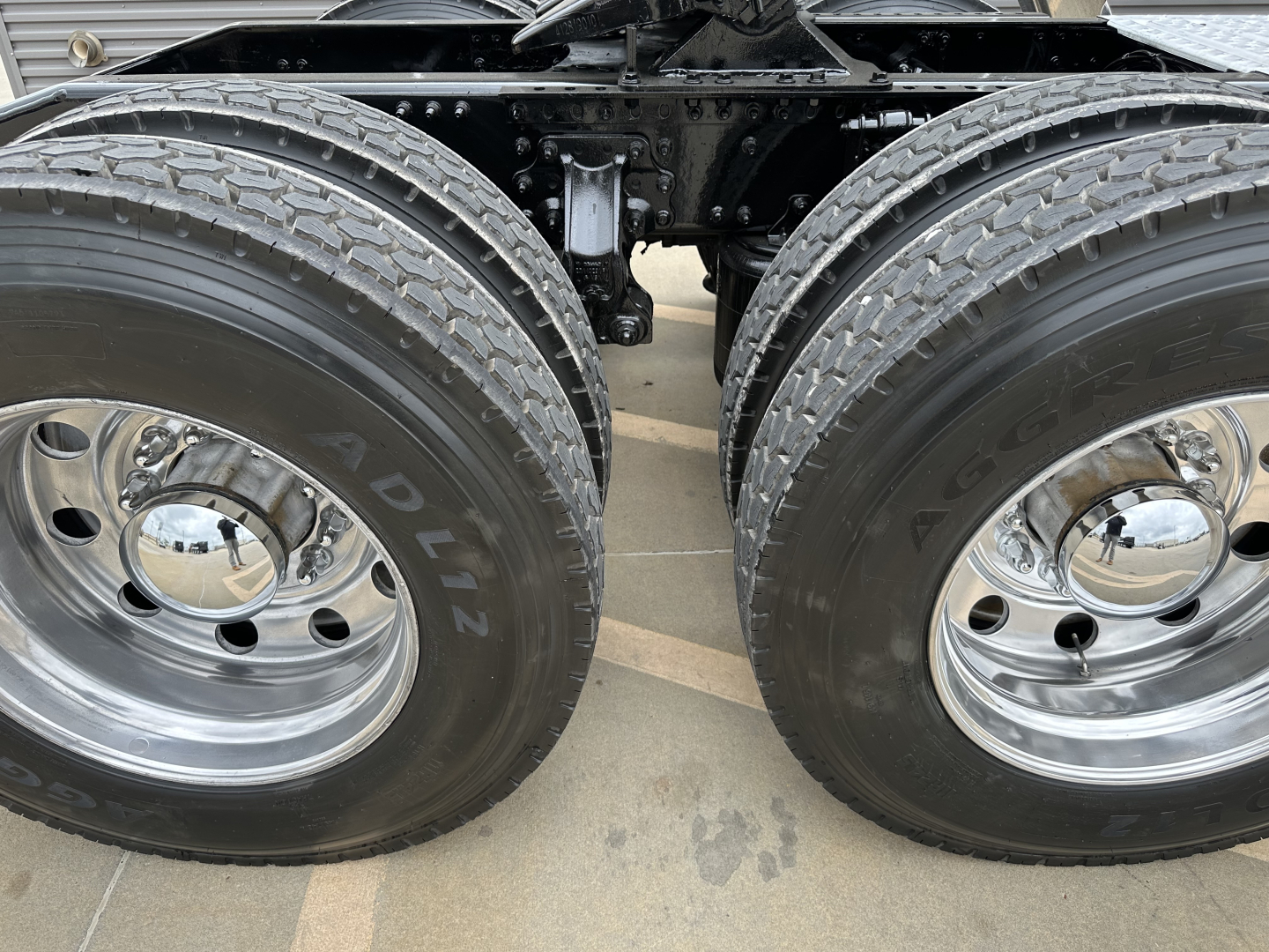 Dual rear wheels of a Mack PA64T truck chassis showing twin tires and chrome hubcaps.