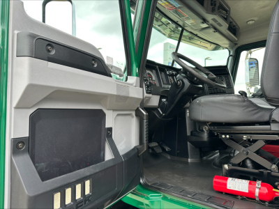 Truck cab interior with door panel and steering wheel; visible text includes none clearly legible.
