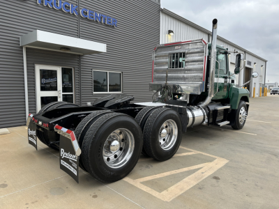 Mack PI64T truck tractor rear and cab view showing dual rear axles, aluminum fuel tanks, and chrome exhaust stacks with stainless sleeper cab area
