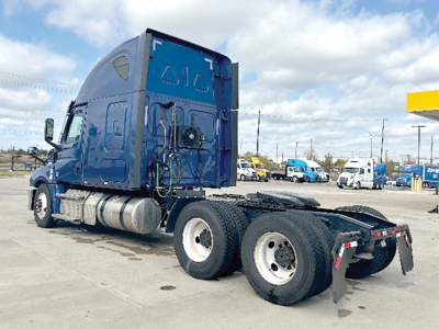 Freightliner Cascadia 126 tractor rear view showing dual rear axles and blue sleeper cab.