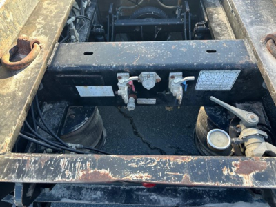 Trailer battery/controller area of a Load King 55 Ton lowboy showing electrical connectors and hydraulic line manifold.