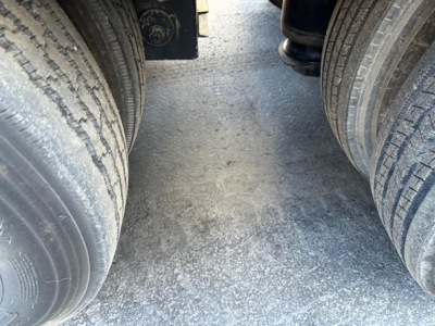Trailer view showing dual rear axles and tires on a Load King 55 Ton Lowboy, with surface grip and wheel hubs visible.