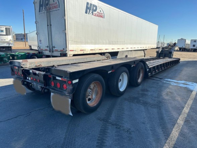 Load King 55 Ton lowboy trailer showing tandem rear axles and heavy-duty deck with auger wheel wells and rear lights.