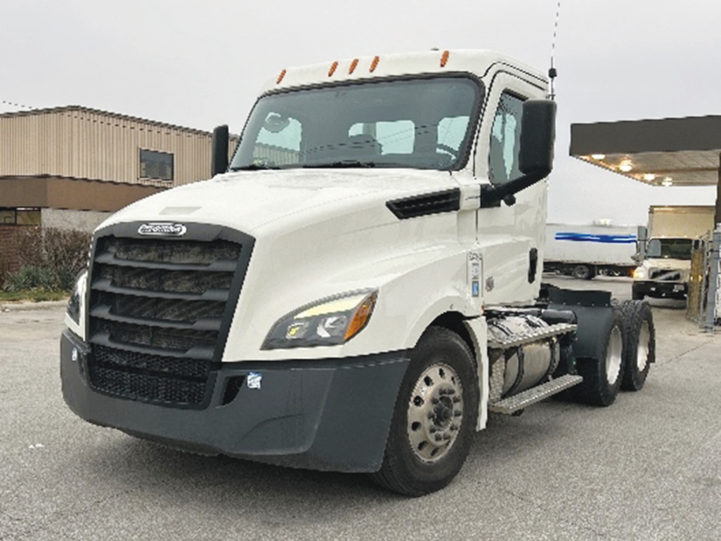 Truck cab and chassis of a 2019 Freightliner Cascadia 126 Conventional Daycab showing front grille and driver side view.