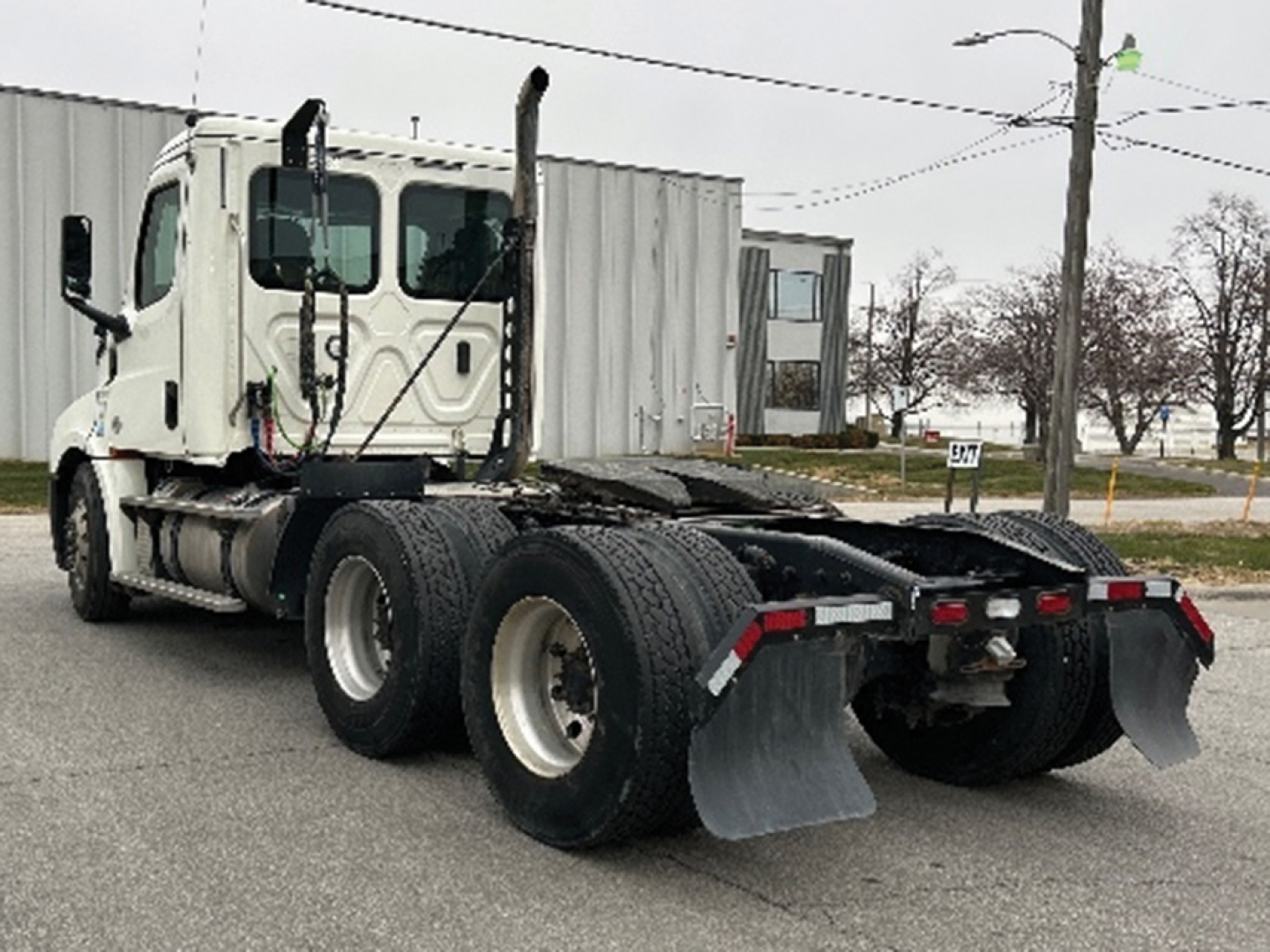 Truck chassis with dual rear axles and mud flaps; visible branding and numbers not legible from distance.