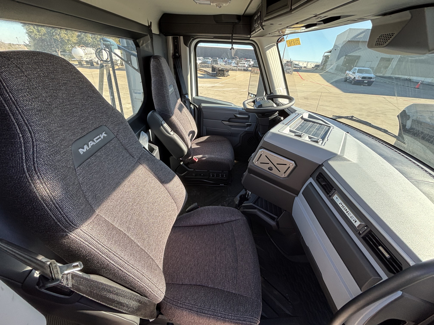 Mack PR64T truck interior showing driver seat and dashboard with steering wheel and control panel.