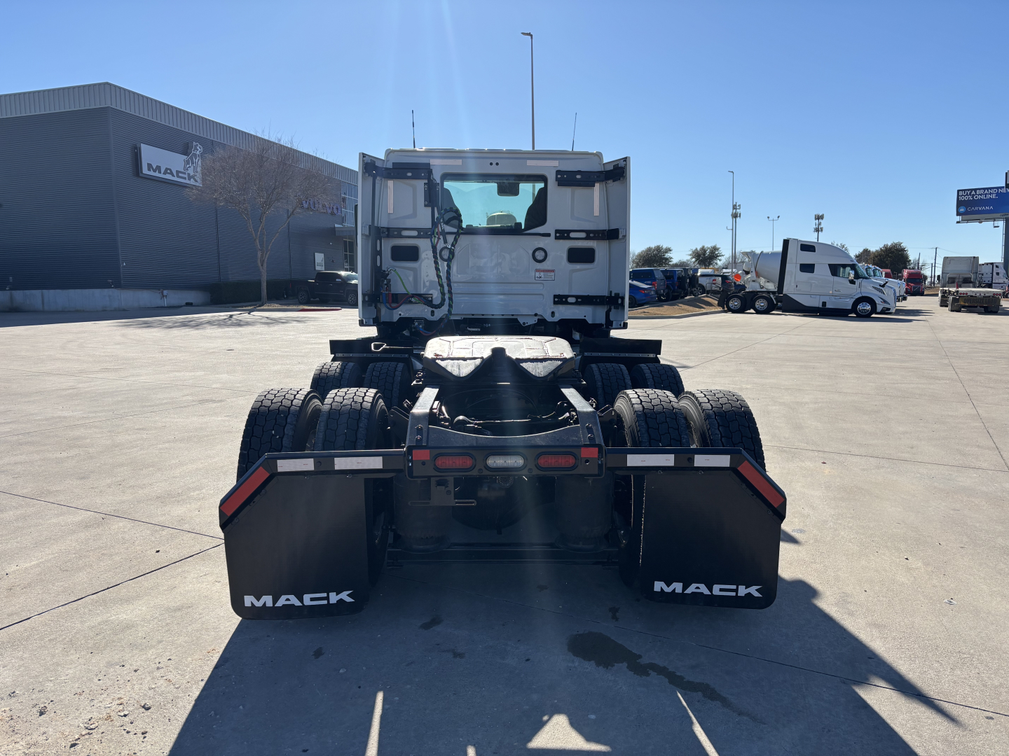 Mack PR64T truck chassis rear view showing dual rear axles, fifth-wheel area, and Mack mud flaps with white Mack branding.