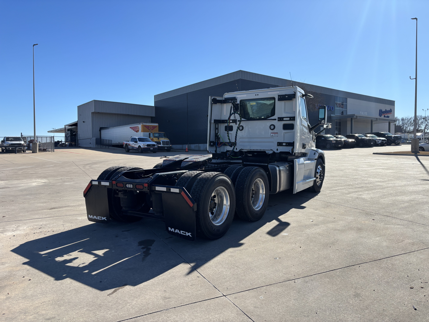 Mack PR64T truck tractor rear and side view showing chassis and wheels in a dealership lot.