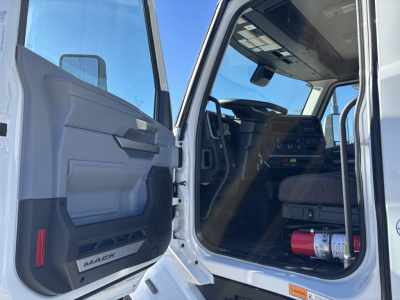 Mack PR64T cab interior and open driver door showing dashboard and steering wheel.