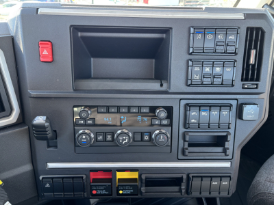 Truck cab dashboard with climate controls, toggle switches, and storage pocket visible.