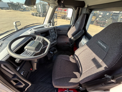 Interior of 2027 Mack PR64T truck cab showing driver's seat and steering wheel with Mack branding on seat cover.