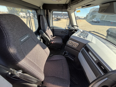 Mack PR64T truck interior showing driver seat and dashboard with steering wheel and control panel.
