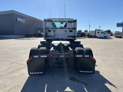 Mack PR64T truck chassis rear view showing dual rear axles, fifth-wheel area, and Mack mud flaps with white Mack branding.